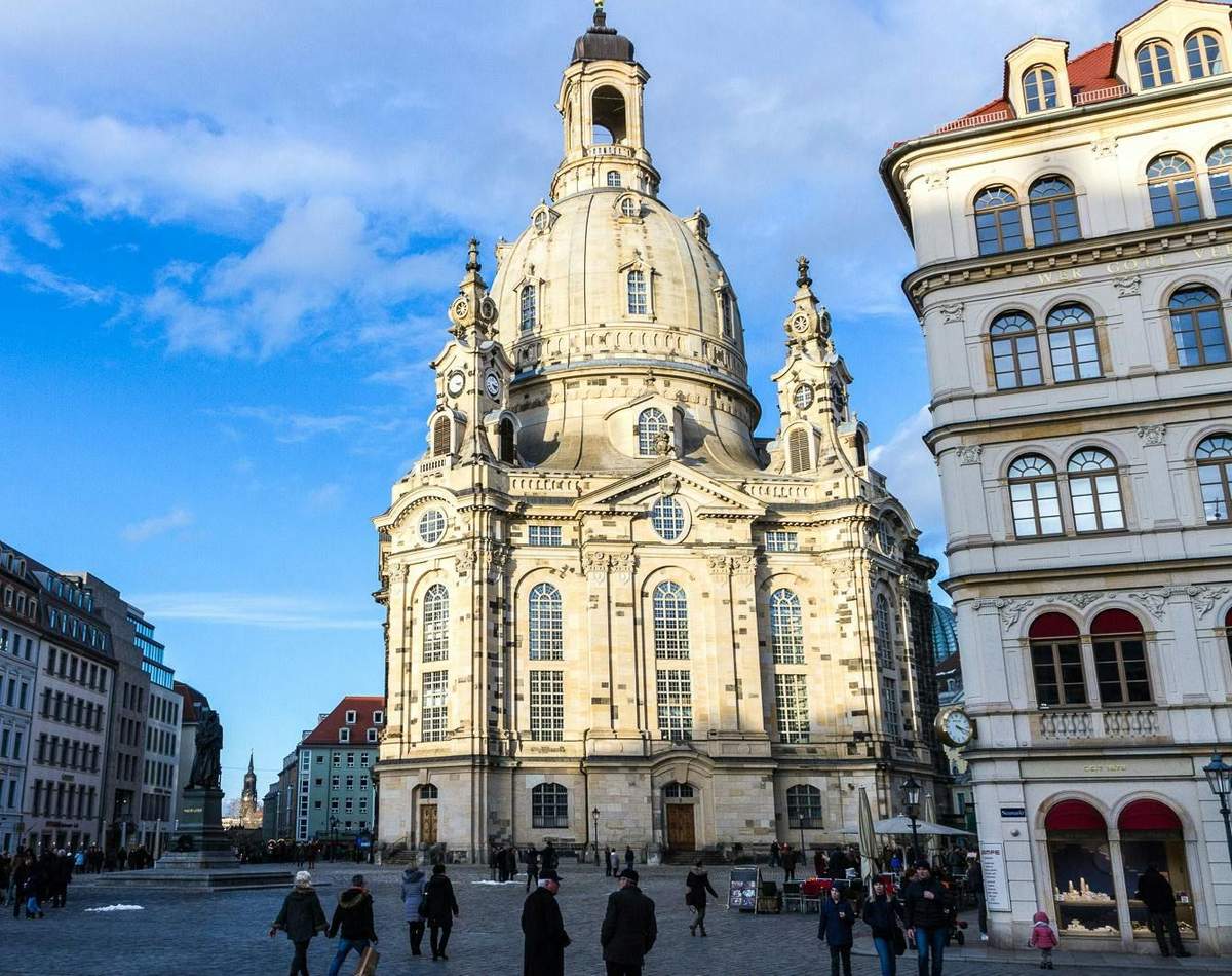 Città Vecchia di Dresda, Frauenkirche (Interno) e Zwinger: Tour Guidato Un grande edificio in stile barocco con una grande cupola in una giornata di sole, persone che camminano in primo piano, circondate da altri edifici.
