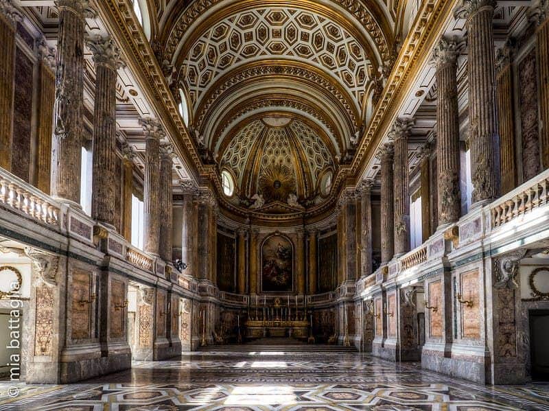 Royal Palace of Caserta: Priority Entry Ticket + Roundtrip from Naples Large, ornate hall with high, domed ceiling, intricate patterns, tall columns, and decorative marble floor.