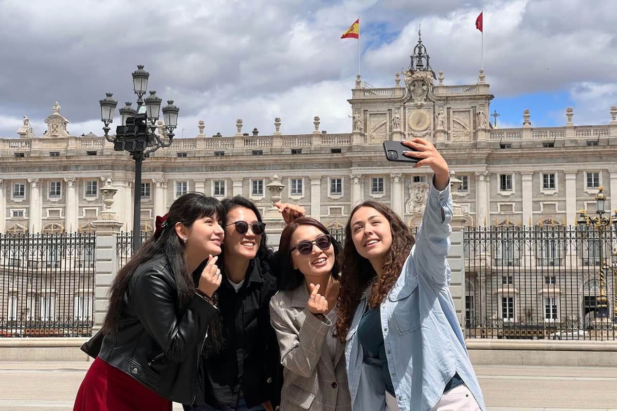 Madrid: Visita guiada ao centro histórico + entrada e visita rápida ao Palácio Real Grupo tirando uma foto em frente ao Palácio Real de Madri