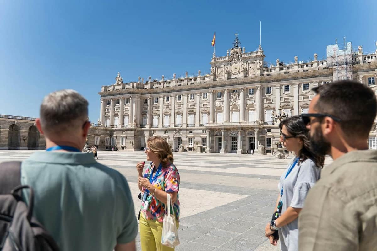 Group of people in front of an ornate, historic building with a clear blue sky.