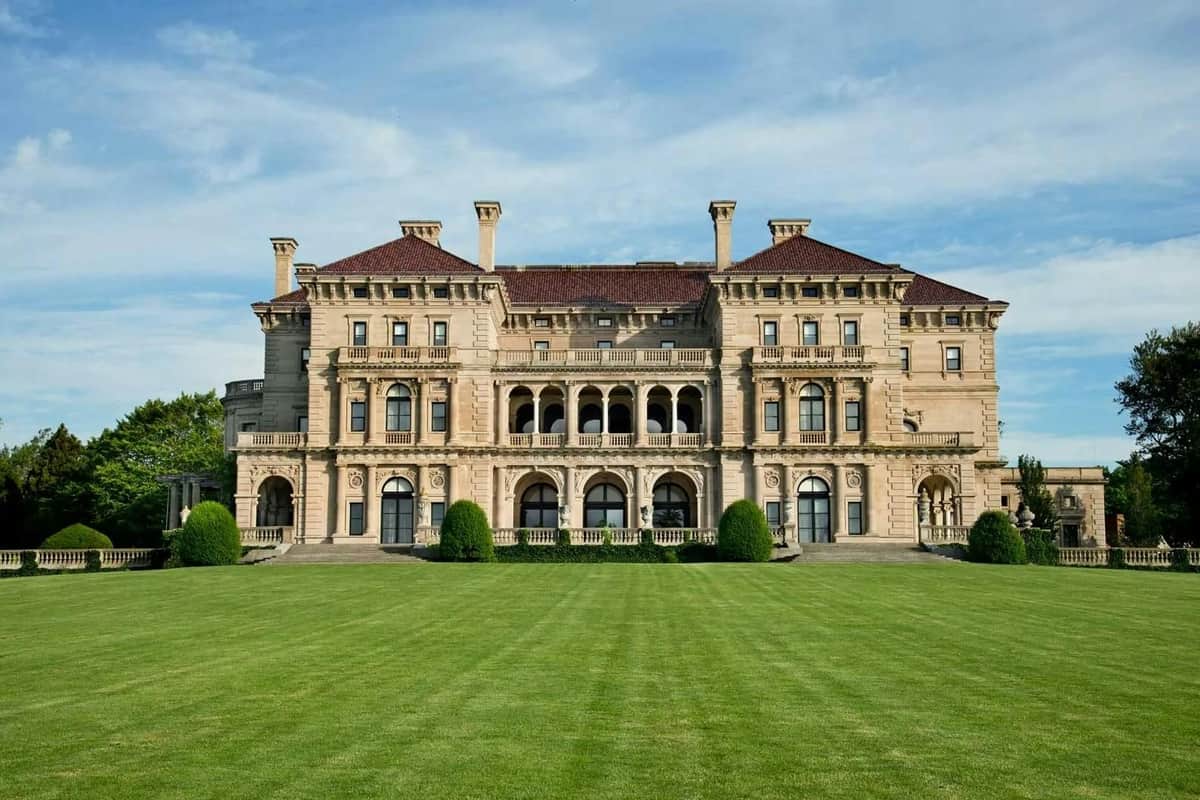 The Breakers: Entry Ticket A large, ornate mansion with symmetrical architecture, arched windows, and a well-manicured lawn under a blue sky.