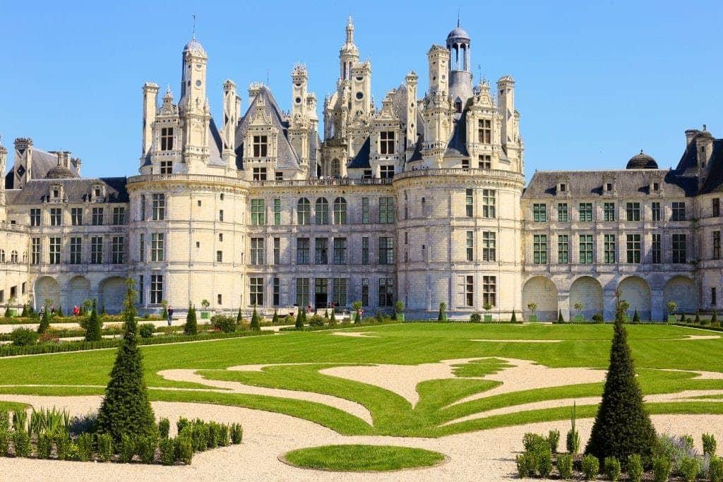 Château de Chambord Elaborate, historic château with intricate towers and manicured gardens under a clear blue sky.